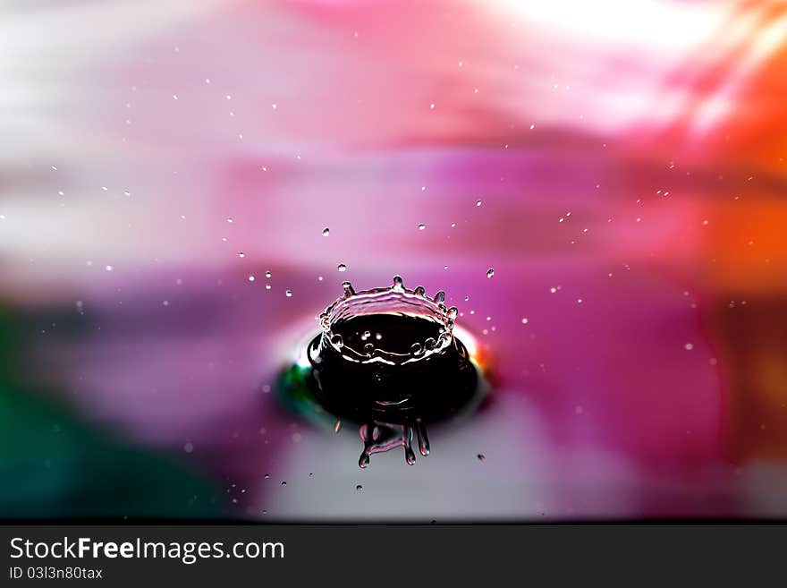 A drop of water splashing in pink. A drop of water splashing in pink