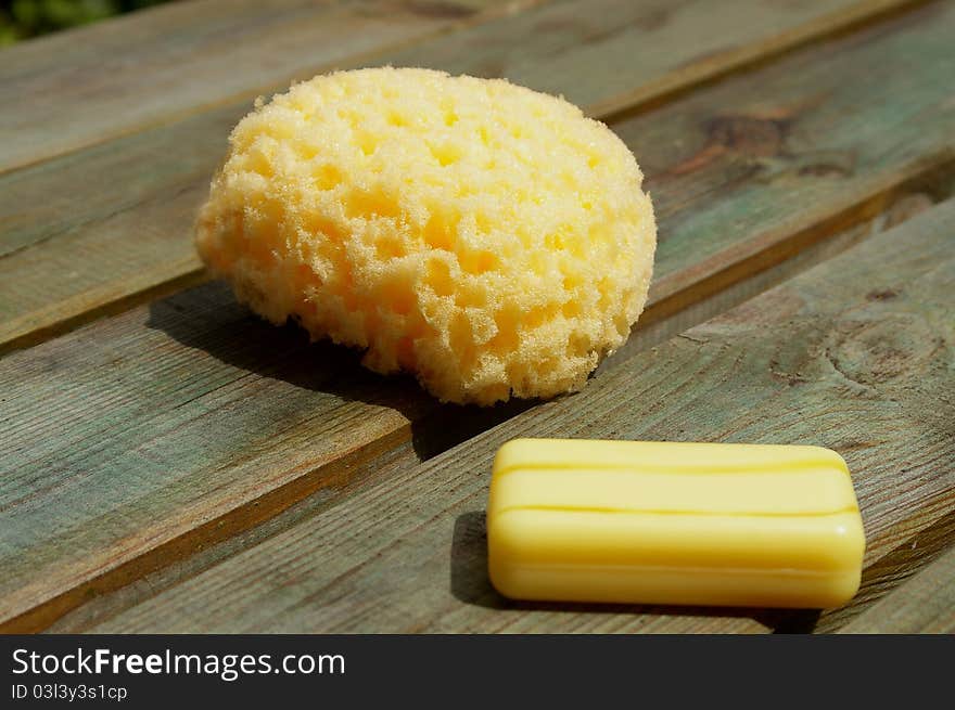 Yellow sponge and soap on coarse wood panels/planks. Yellow sponge and soap on coarse wood panels/planks