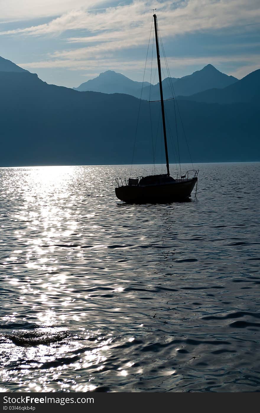 The image depicts the silhouette of a sailboat that was anchored until the next day. The image depicts the silhouette of a sailboat that was anchored until the next day.