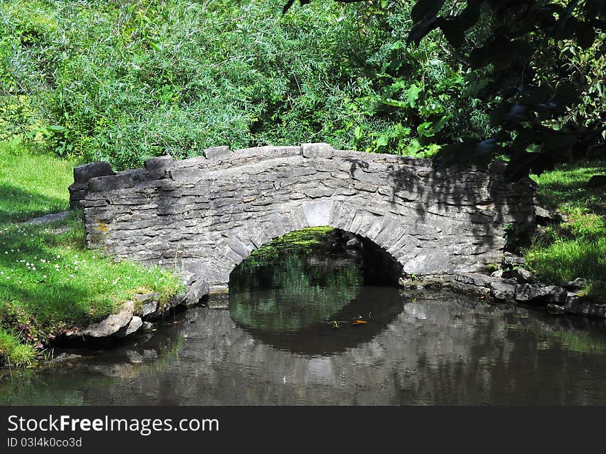 An old stone bridge for path over a creek. An old stone bridge for path over a creek