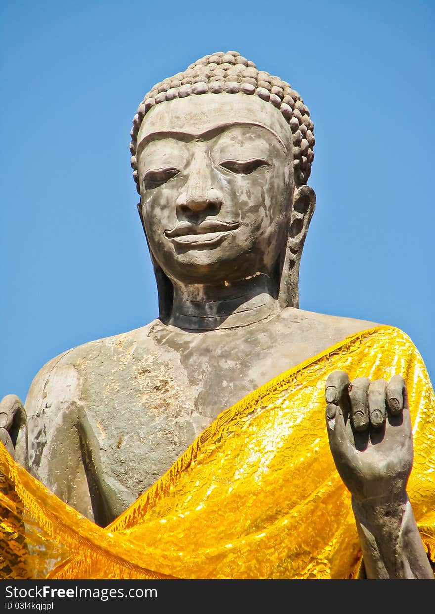 Stone old buddha image in a temple with blue sky. Stone old buddha image in a temple with blue sky