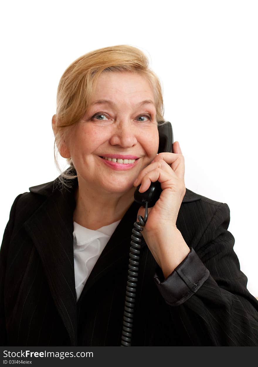 Senior Woman talking on the phone in black suite on white background. Blond hair. Shot in studio.