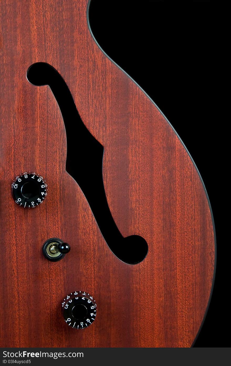 Closeup of an f hole in a cherry wood hollow body guitar. Closeup of an f hole in a cherry wood hollow body guitar