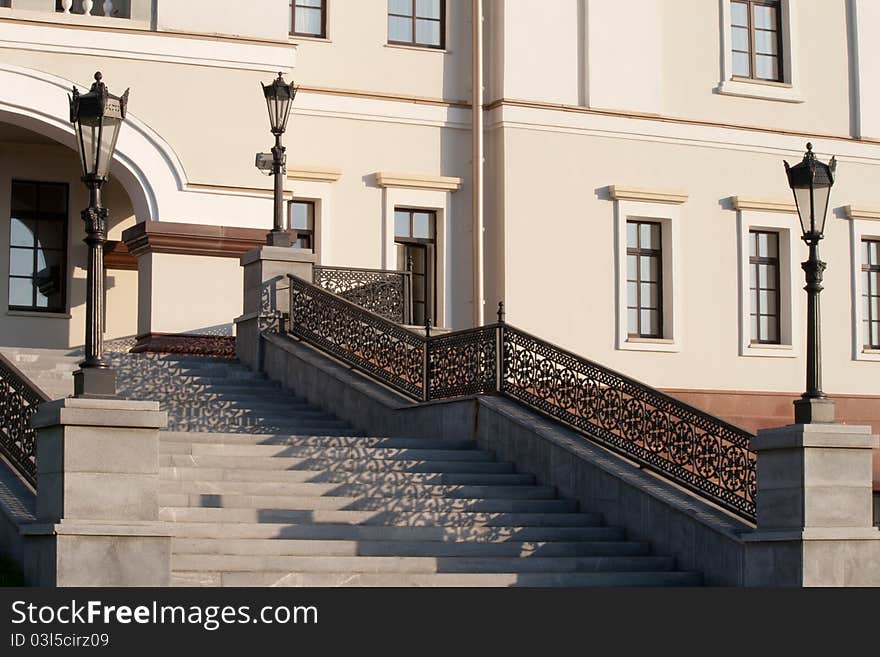 Stairs with beautiful wrought-iron railings and light building