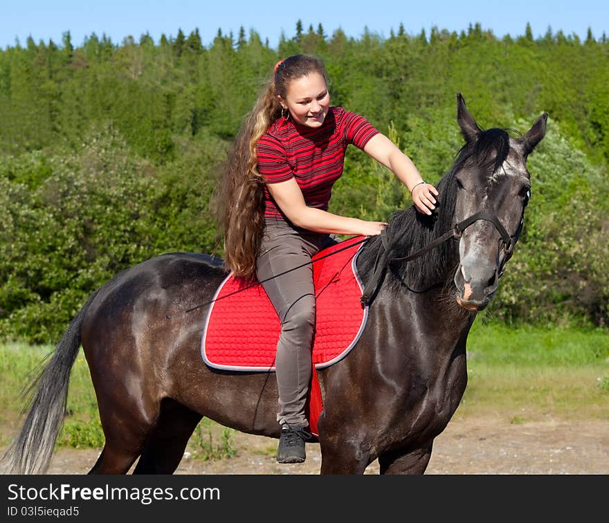 A girl with her hair stroking horse