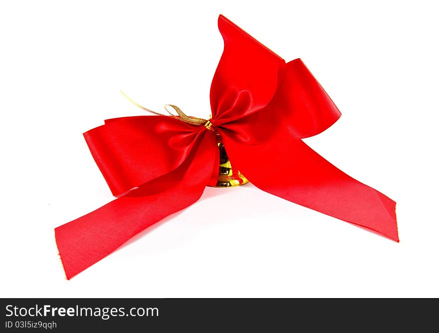 Ribbon golden bell with red satin bow isolated on white