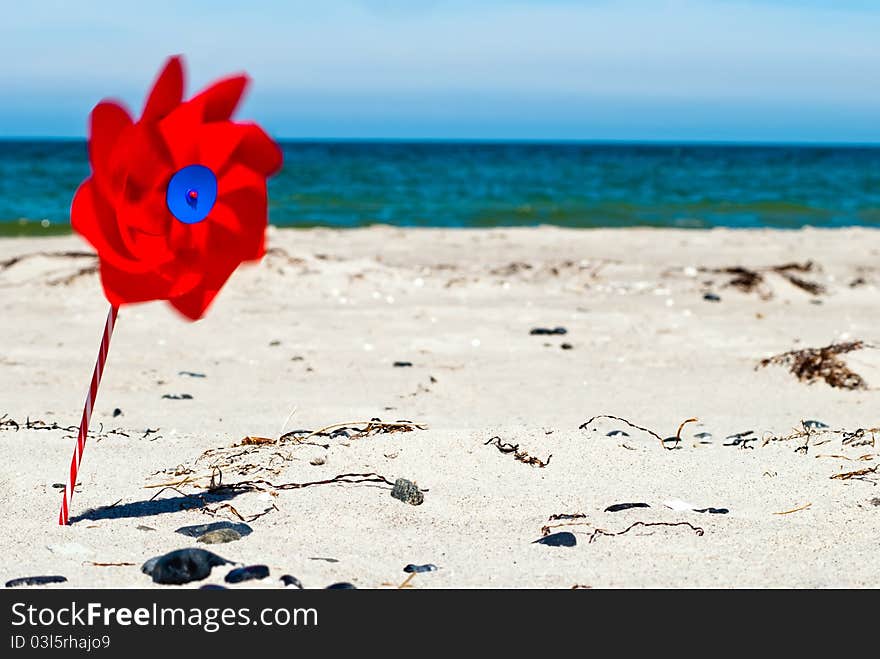 Red wind turbine on the beach