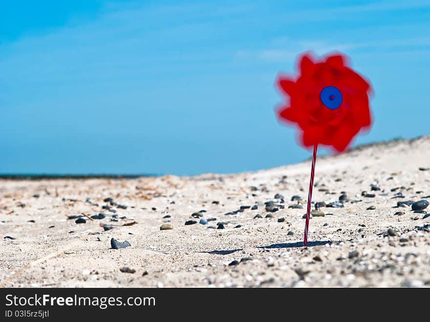 Red wind turbine on the beach