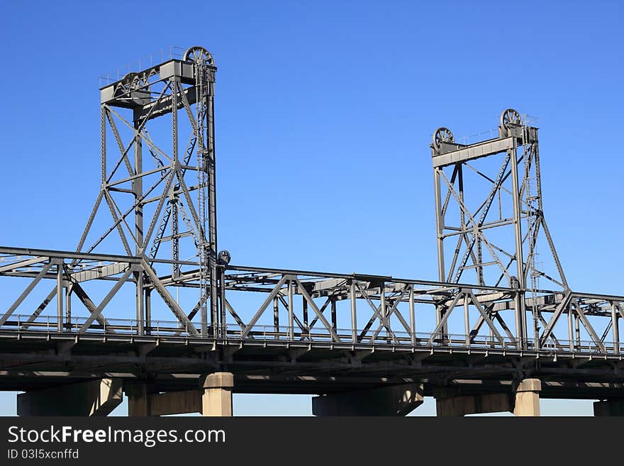 Detail of a vertical-lift bridge (drawbridge) - set against blue sky