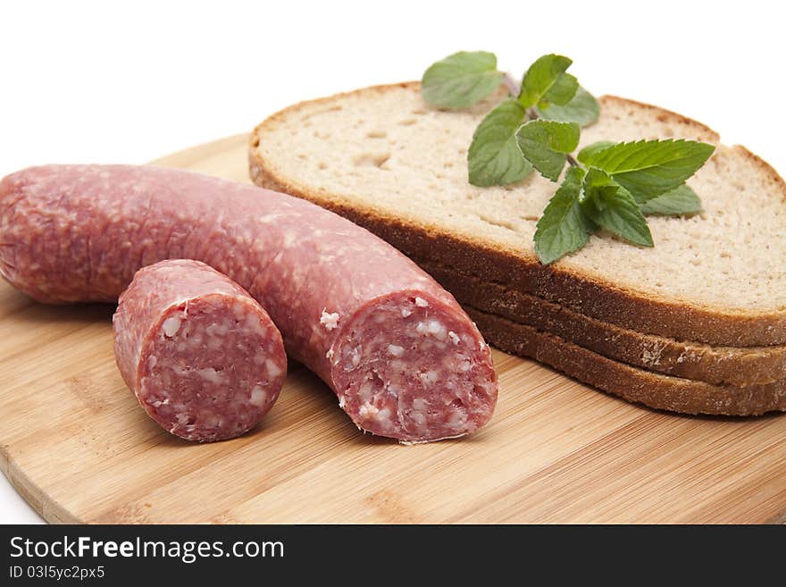 Garlic salami with bread onto wood plates