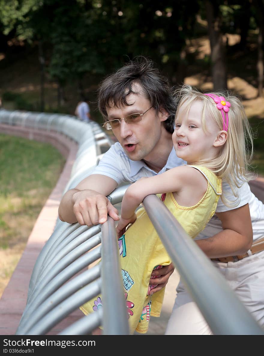 Little happy girl with father at the summer park