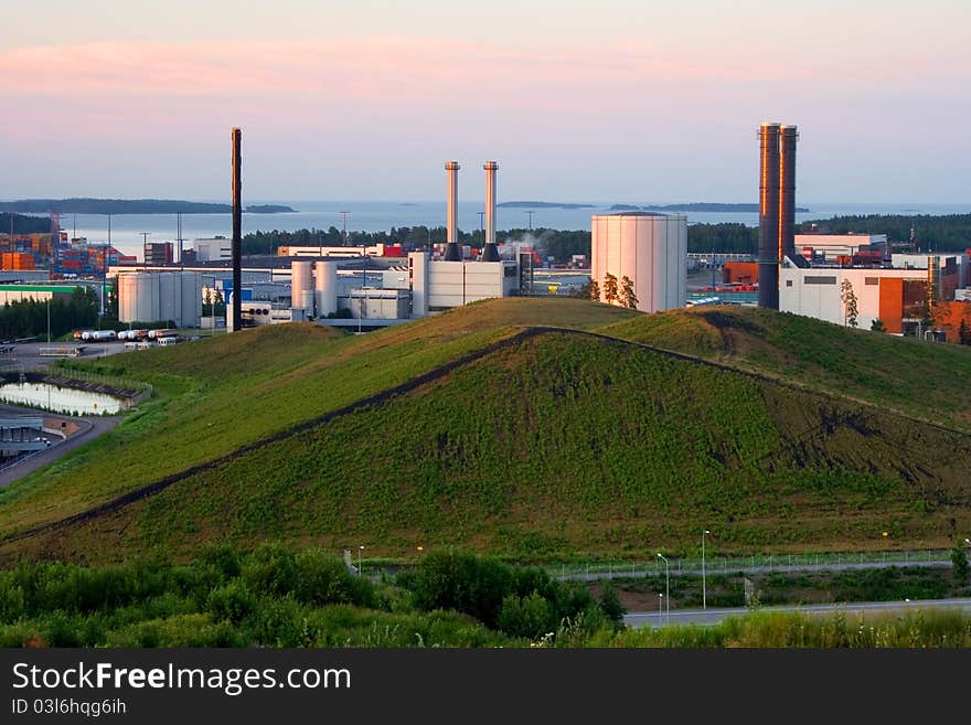 Vuosaari power plants behind the green hill.  The source of energy used at Vuosaari is natural gas. Vuosaari power plants behind the green hill.  The source of energy used at Vuosaari is natural gas.