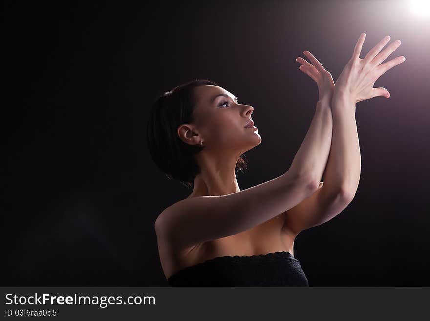 Young beauty woman in dark look at light with yoga sign. Young beauty woman in dark look at light with yoga sign