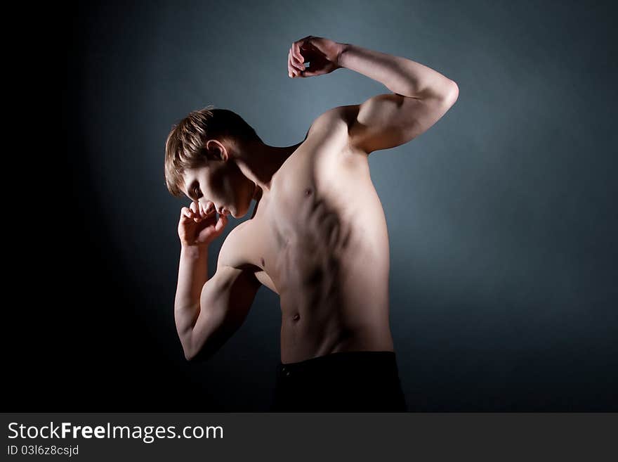 Fashion portrait of the young beautiful man in studio