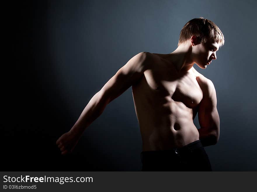 Fashion portrait of the young beautiful man in studio