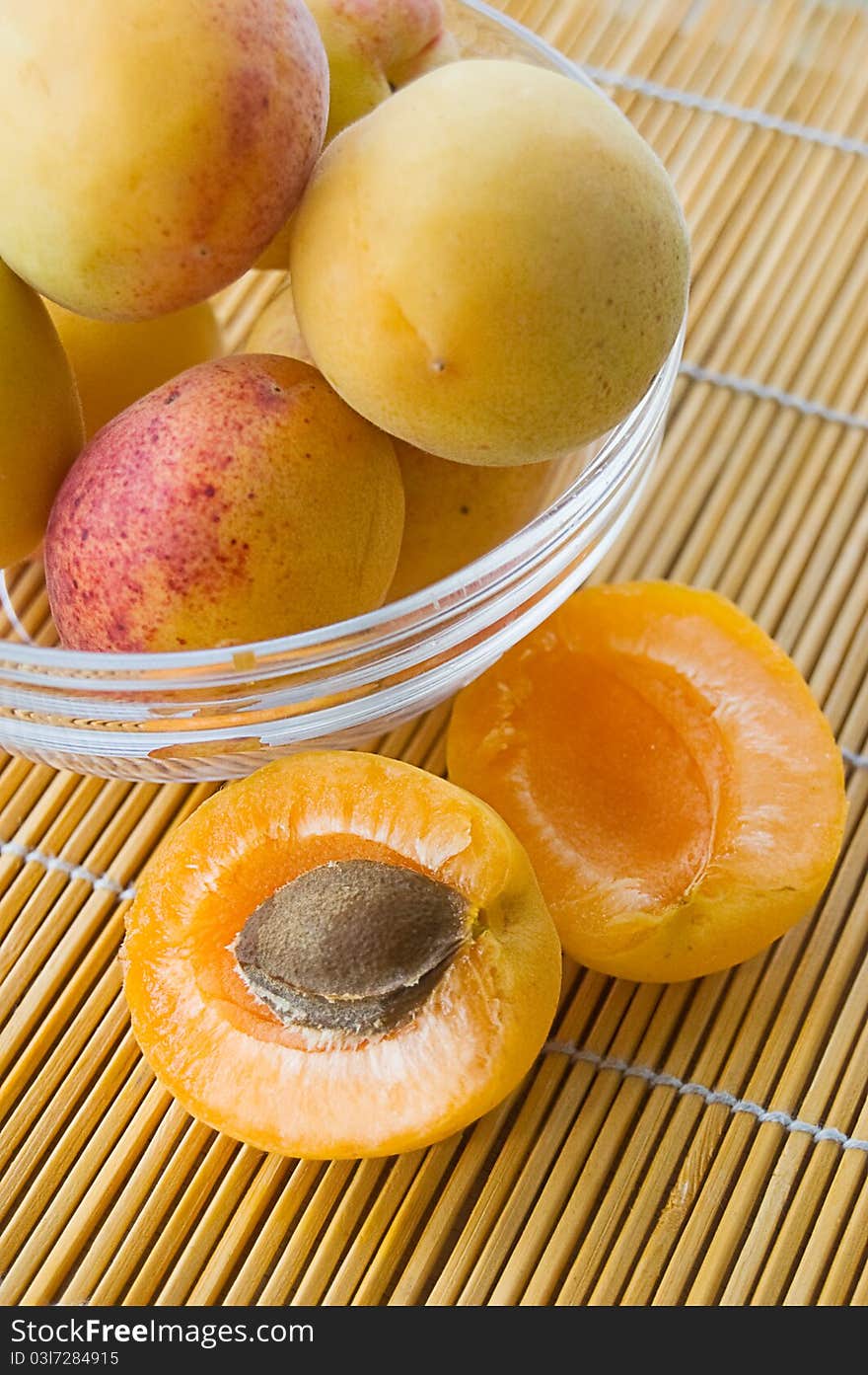 Ripe apricots in plate on table