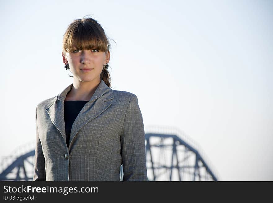 Portrait of young business woman, a blue sky background and metal farm