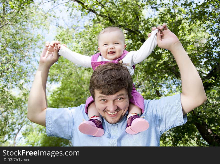 Father playing with baby, baby sitting on father. Father playing with baby, baby sitting on father