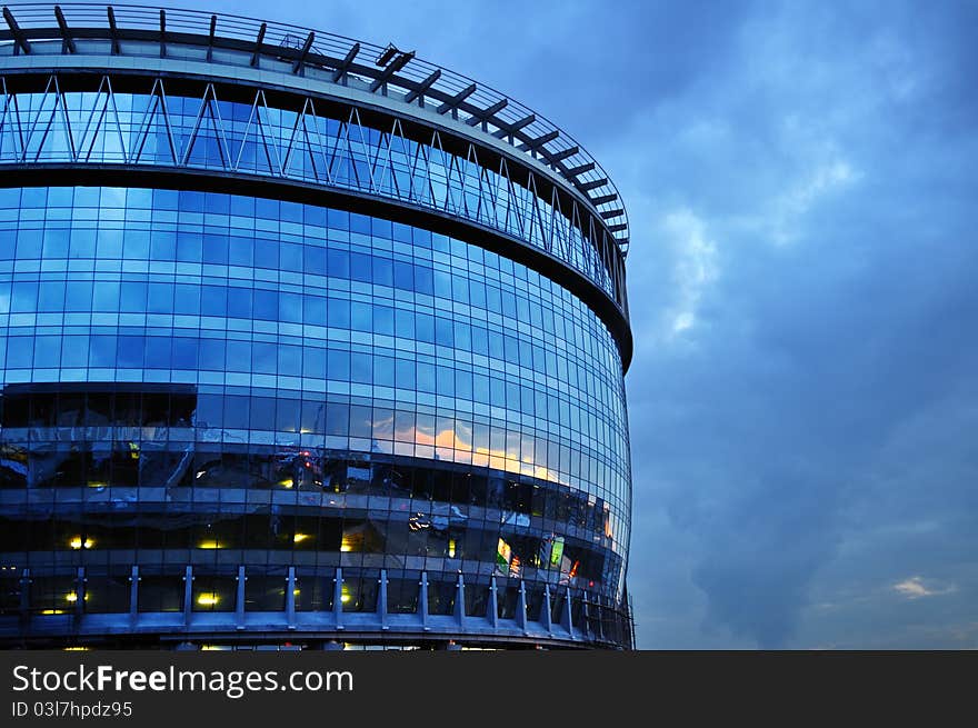 Barrel-like office building with city lights reflections