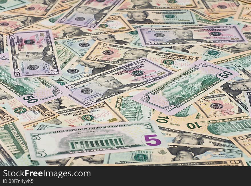 The background of U.S. dollars. Many bills of different denominations. The background of U.S. dollars. Many bills of different denominations