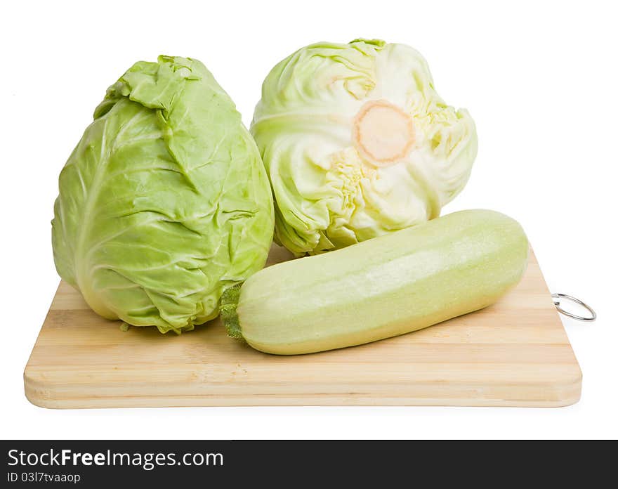 Fresh vegetables on wooden chopping board isolated over white background