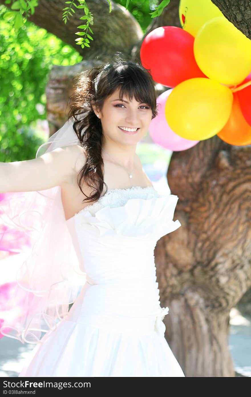 Beautiful Bride with colorful balloons the air