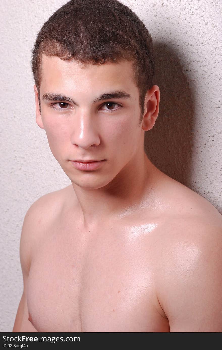 Half body portrait of bare chested young man, light background.