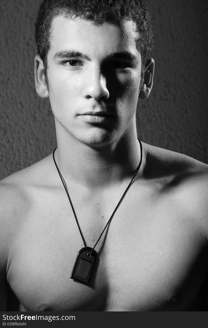 Portrait of bare chested young man, light background.