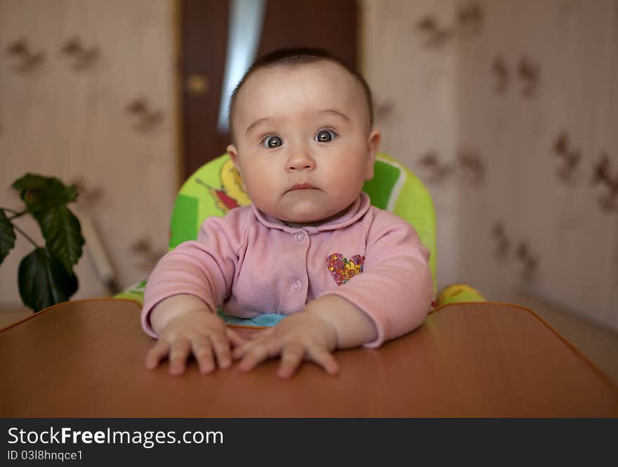 Little girl child sitting at a table and children's laughter