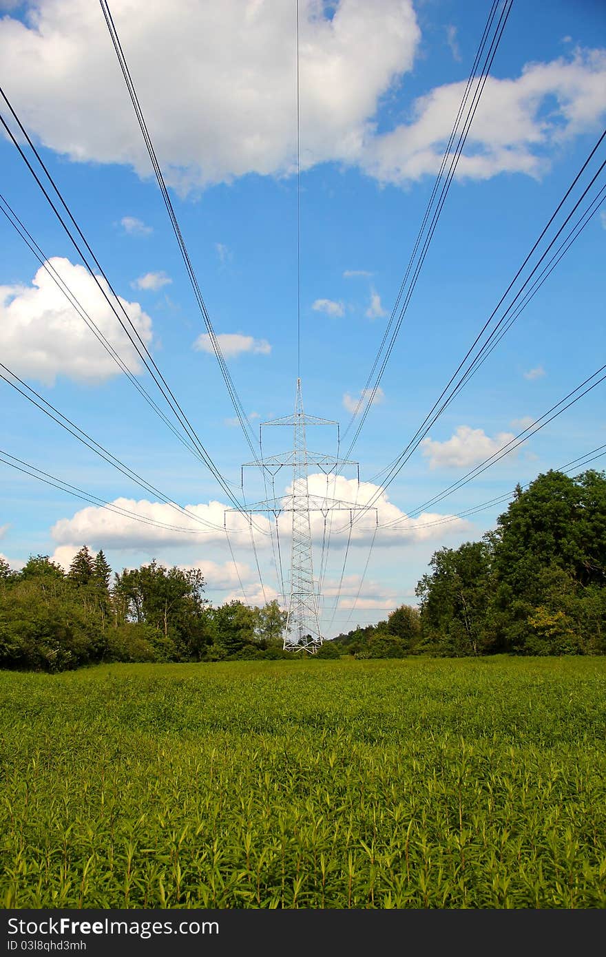 Pylon in front of blue sky, clouds and green landscape. Pylon in front of blue sky, clouds and green landscape