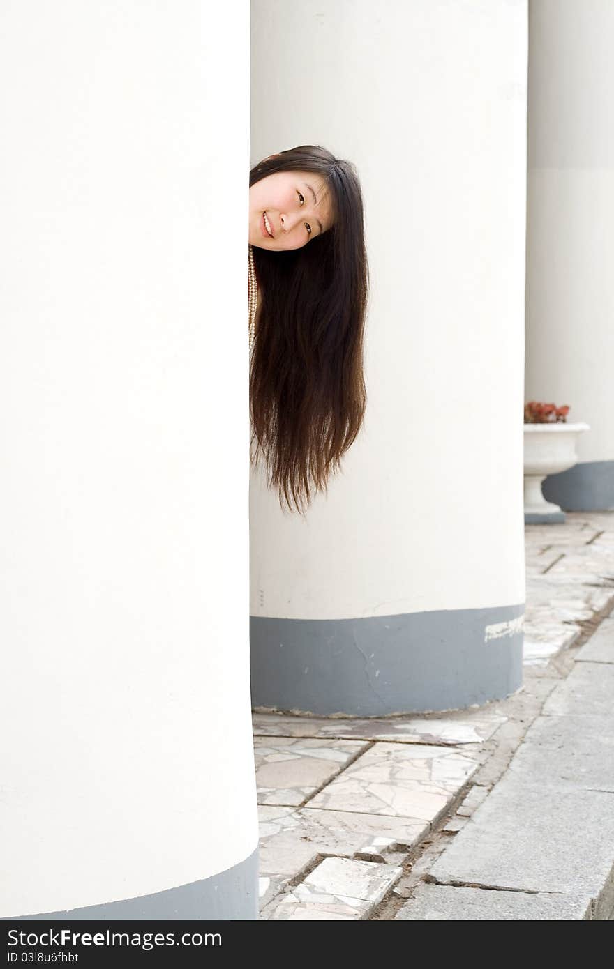 Pretty girl hiding between columns