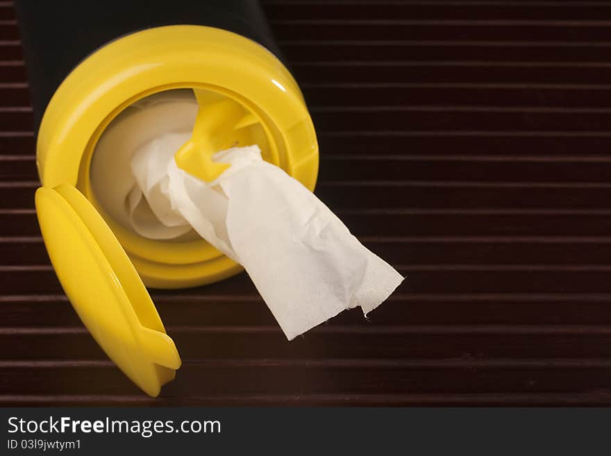 Napkin for cleaning in a plastic container with a wood background. Napkin for cleaning in a plastic container with a wood background.