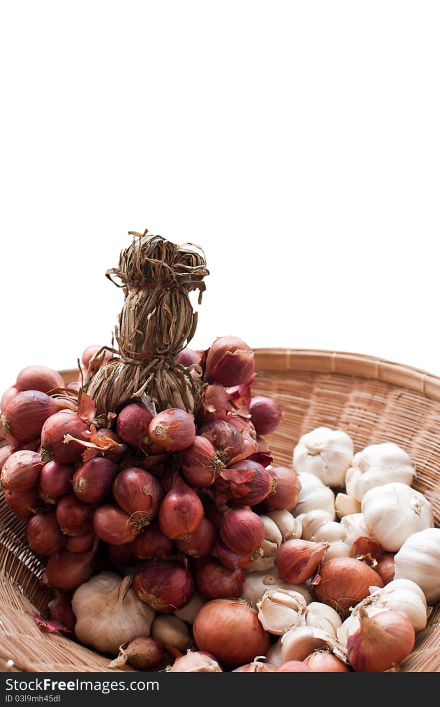 Red onions and garlic in basket isolated background