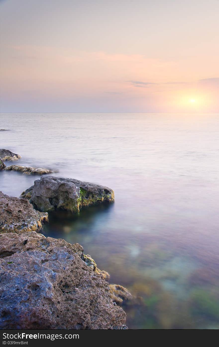 Sea and rock at the sunset. Seascape composition.