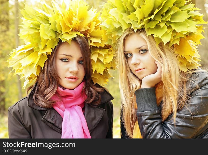 Two beautiful girls in the wreath from leaves. Two beautiful girls in the wreath from leaves