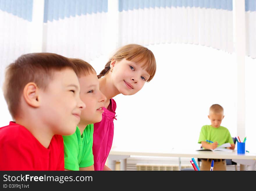 Group classmates standing in a row in the classroom