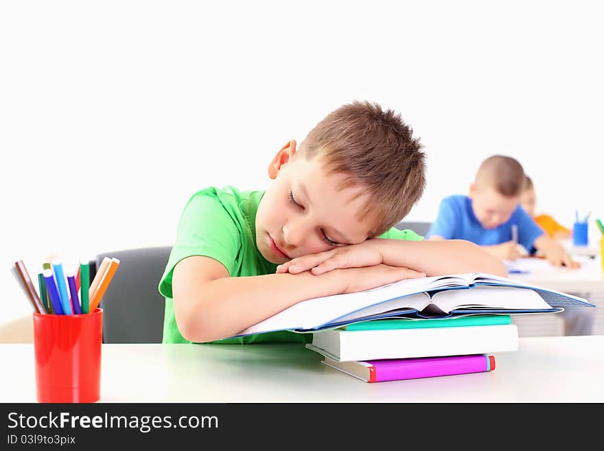 Portrait of a young boy sitting at his desk at school