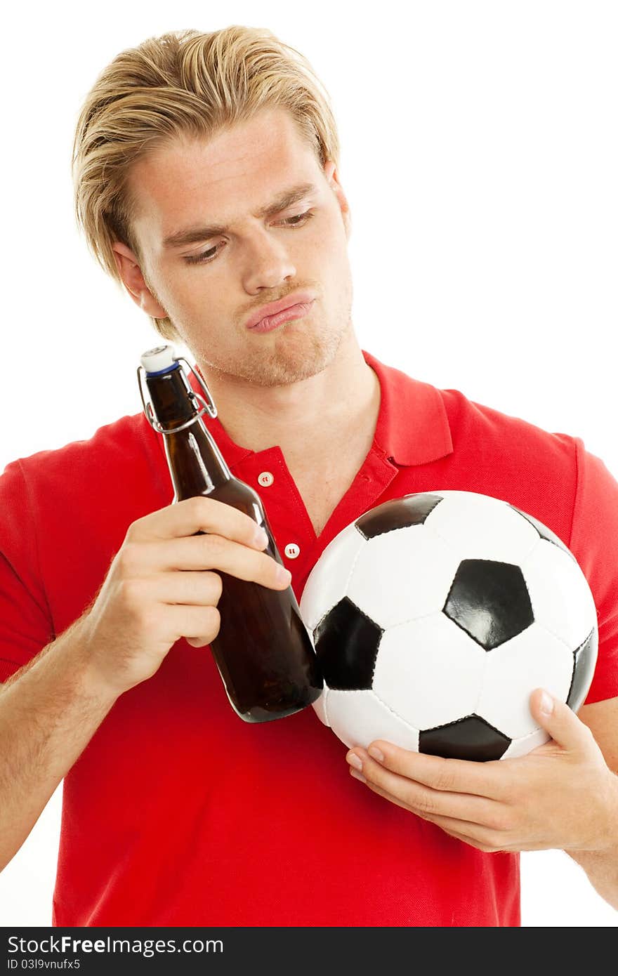 Blond man is looking to his beer and ball