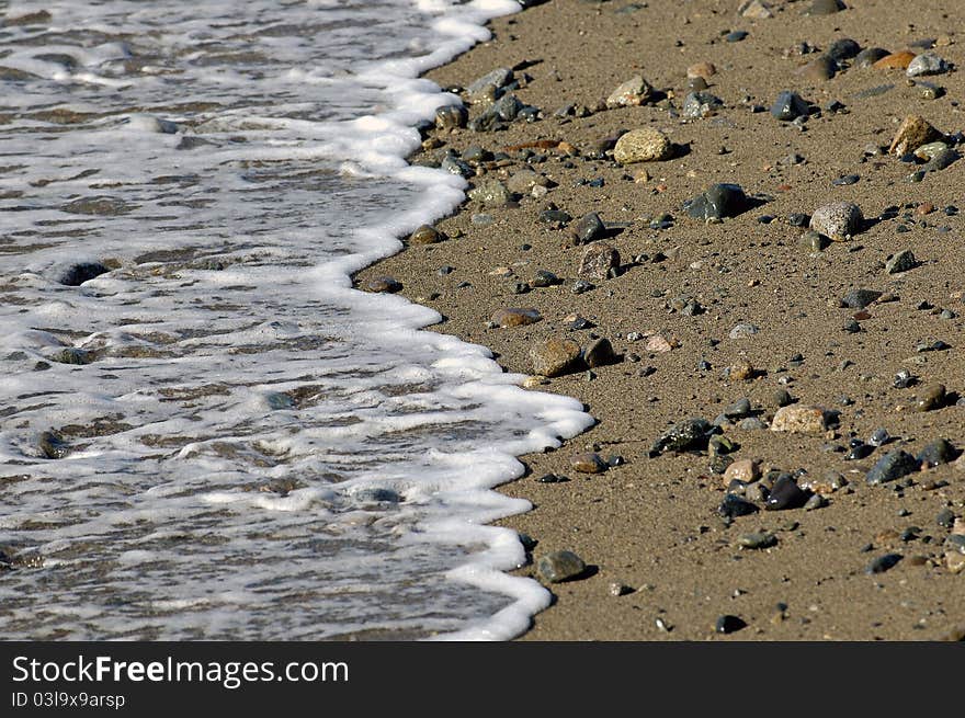 Water froth on the sandy beach