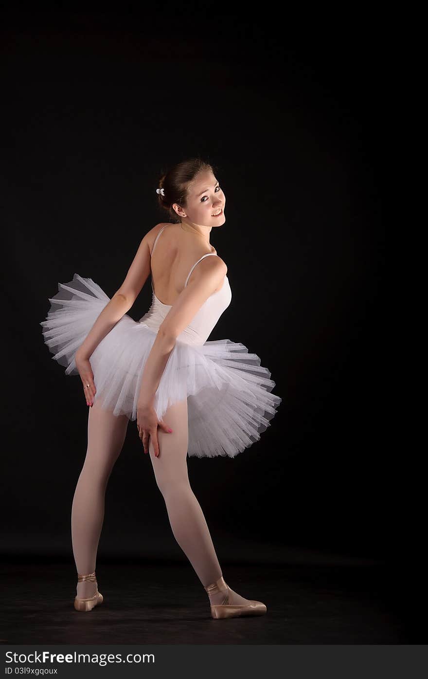 Ballerina in a white skirt and a bathing suit, pointe, dance poses