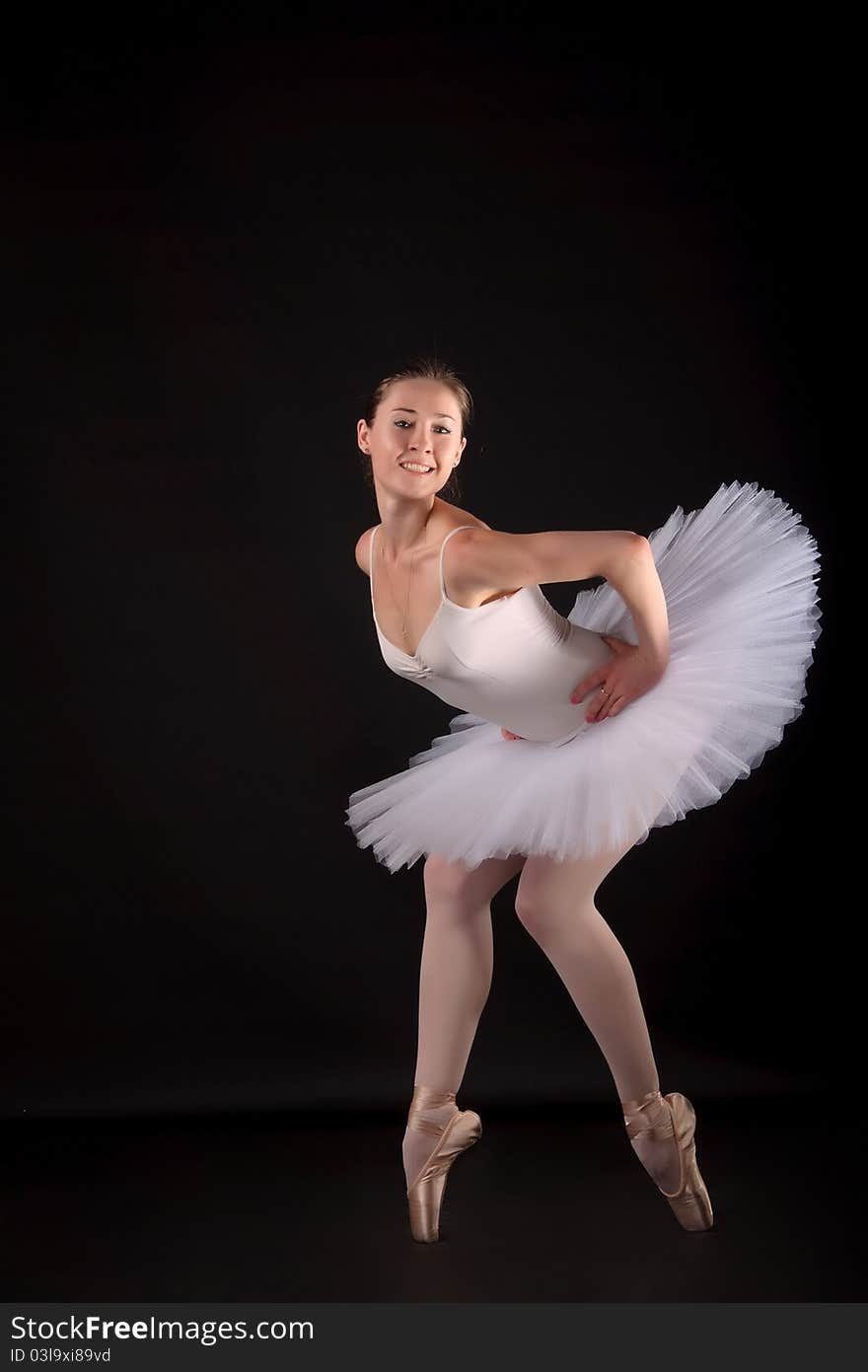 Ballerina in a white skirt and a bathing suit, pointe, dance poses