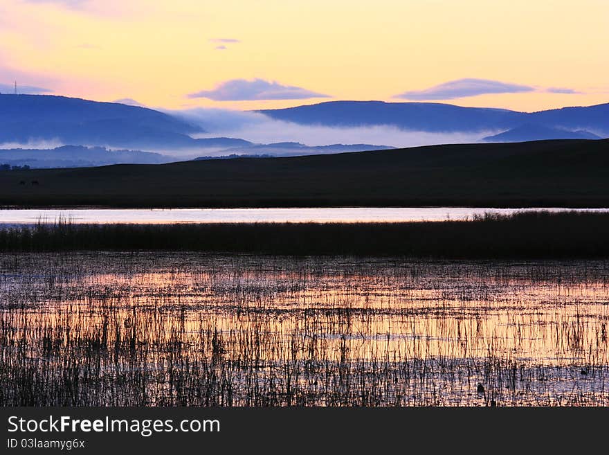 The landscape of sunrise of grassland by the river. The landscape of sunrise of grassland by the river