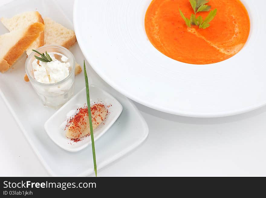 Red soup with bread and spices in a white dish