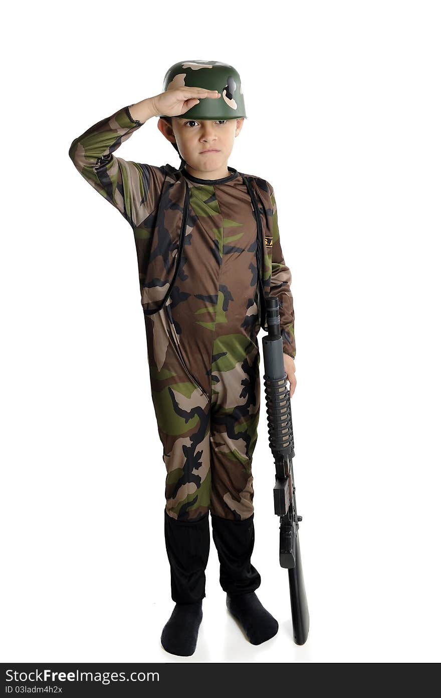 An elementary boy fully dressed in military camouflage and helmet, saluting with his right hand while balancing a toy machine gun with his left. An elementary boy fully dressed in military camouflage and helmet, saluting with his right hand while balancing a toy machine gun with his left.