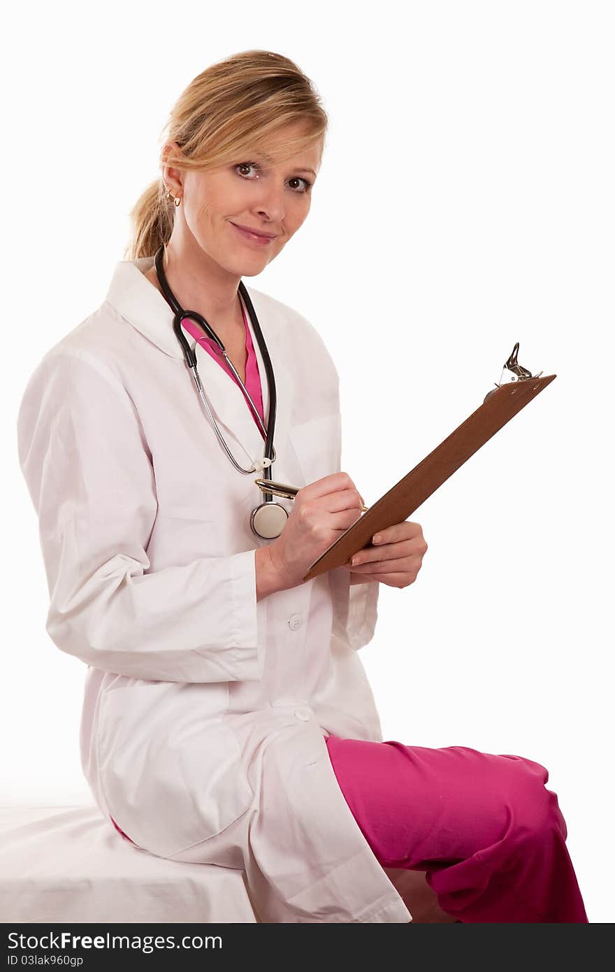 Attractive lady blonde female doctor holding chart wearing pink scrubs and white lab coat. Attractive lady blonde female doctor holding chart wearing pink scrubs and white lab coat