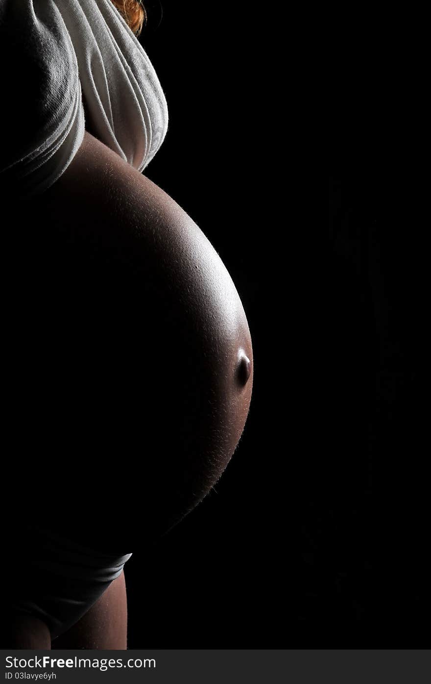 Pregnant woman on black background