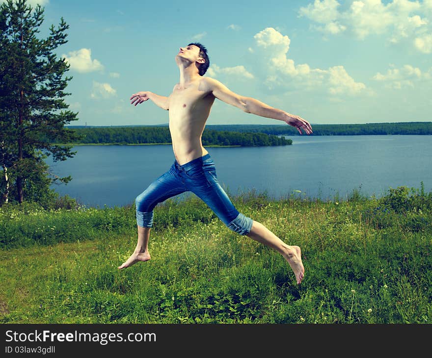 Photo of young happy man to jump on the summer meadow. Photo of young happy man to jump on the summer meadow