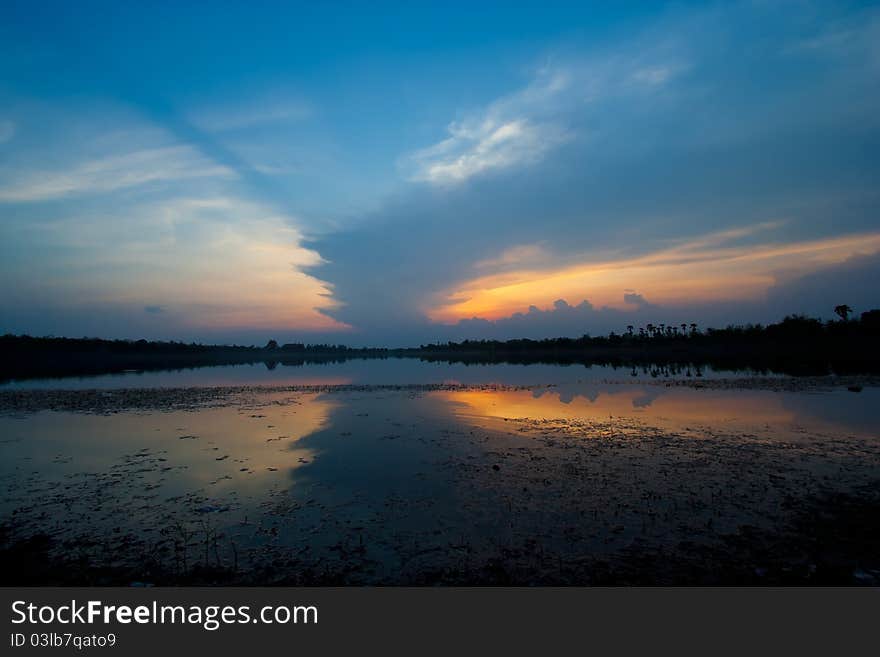 Cloudscape of sunset with blue sky and lake.