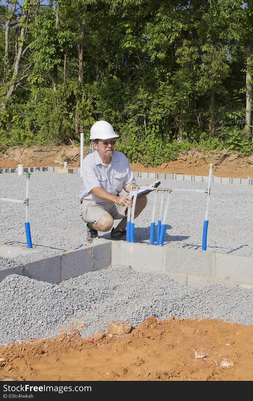 Building inspector checking new plumbing for water coming into new residential community