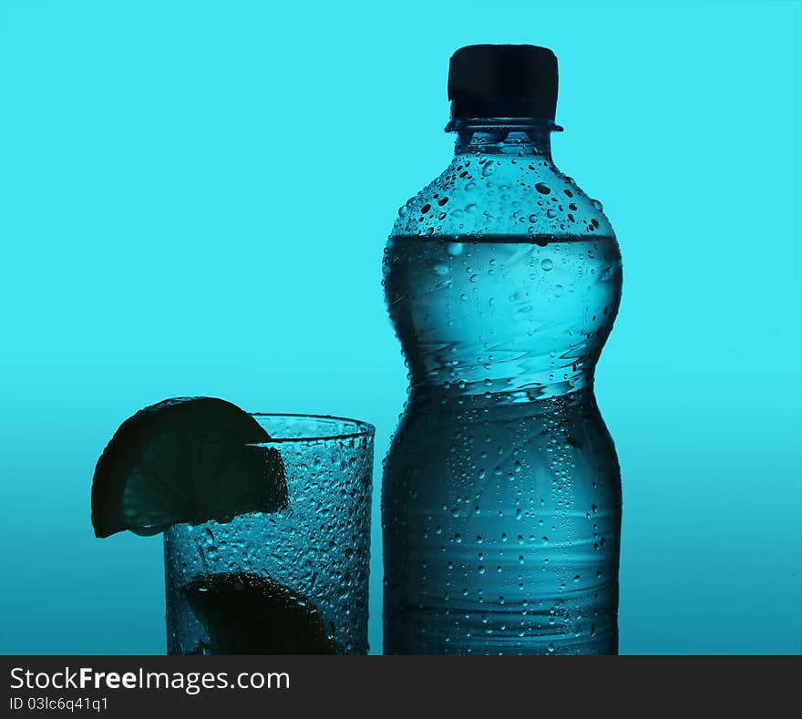 Silhouette of bottle and glass over blue background